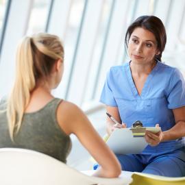 nurse meeting with teenage girl in modern hospital