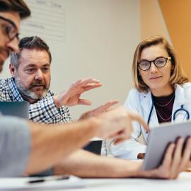 Healthcare professionals discussing over a tablet