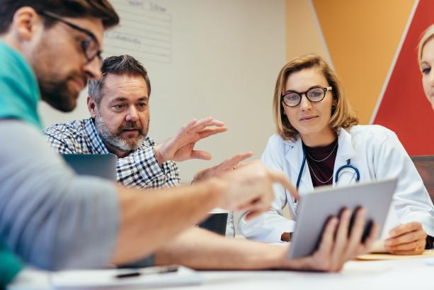 Healthcare professionals discussing over a tablet