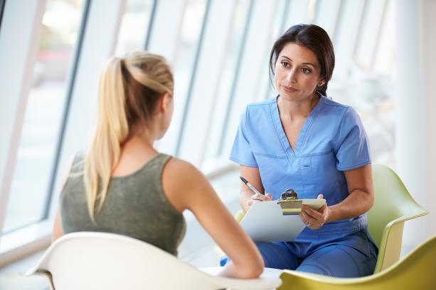 nurse meeting with teenage girl in modern hospital